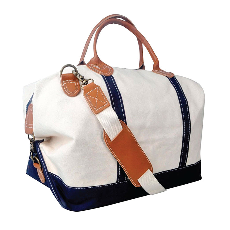 White and navy duffel bag with brown leather straps on a white background