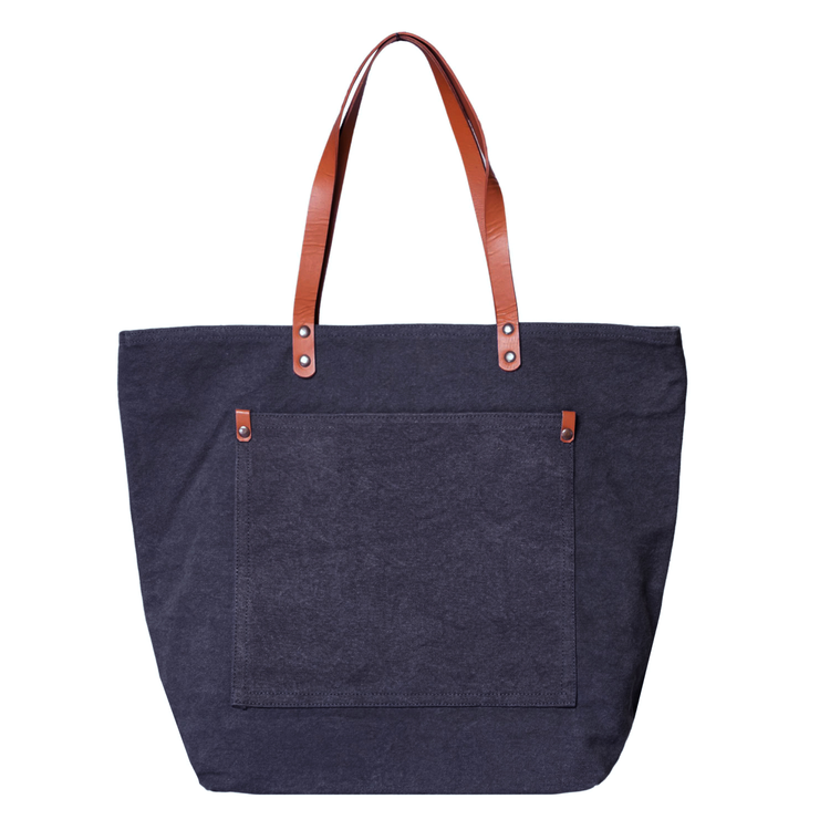 Navy tote bag with brown leather straps on a white background