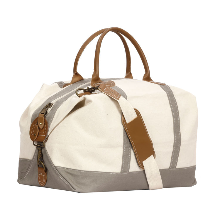 Canvas duffel bag with brown straps and accents on a white background