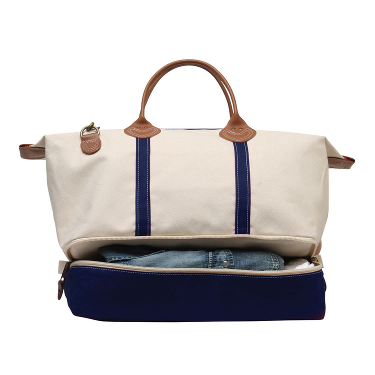 Canvas travel bag with blue stripes and brown handles on a white background