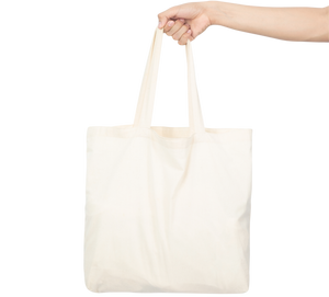 White tote bag held by a hand on a white background